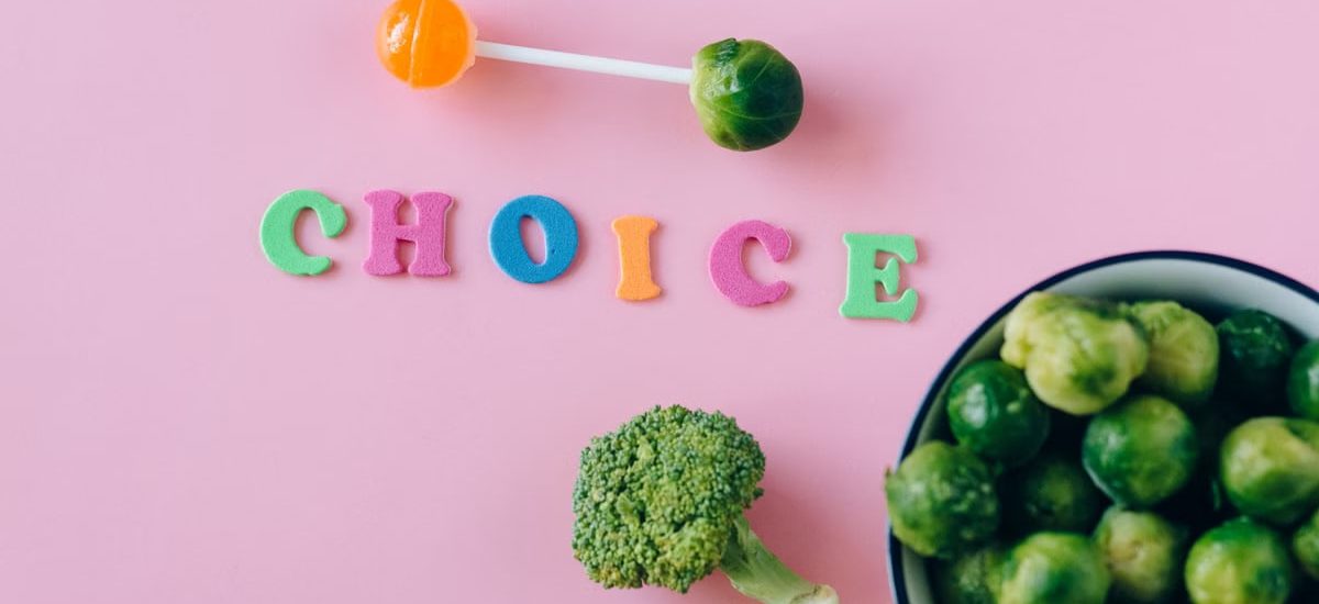 Colorful depiction of healthy and sweet food choices on pink backdrop.