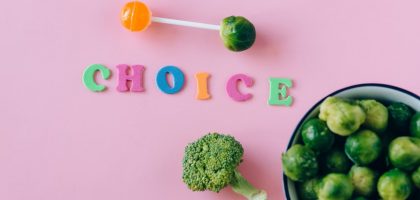 Colorful depiction of healthy and sweet food choices on pink backdrop.