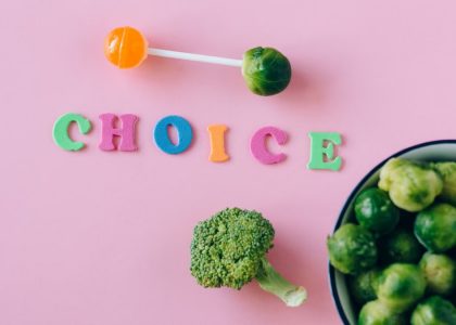 Colorful depiction of healthy and sweet food choices on pink backdrop.