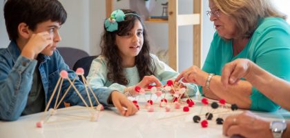 Grandmother playing educational games with grandchildren indoors, fostering creativity and learning.