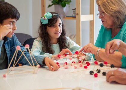 Grandmother playing educational games with grandchildren indoors, fostering creativity and learning.